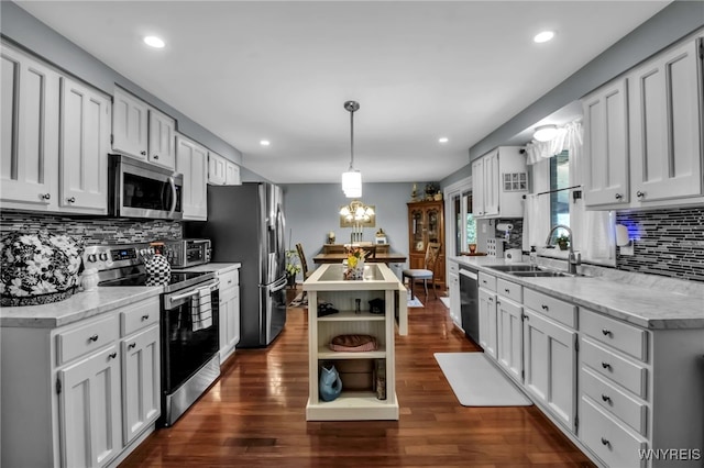 kitchen featuring tasteful backsplash, open shelves, a sink, appliances with stainless steel finishes, and a center island