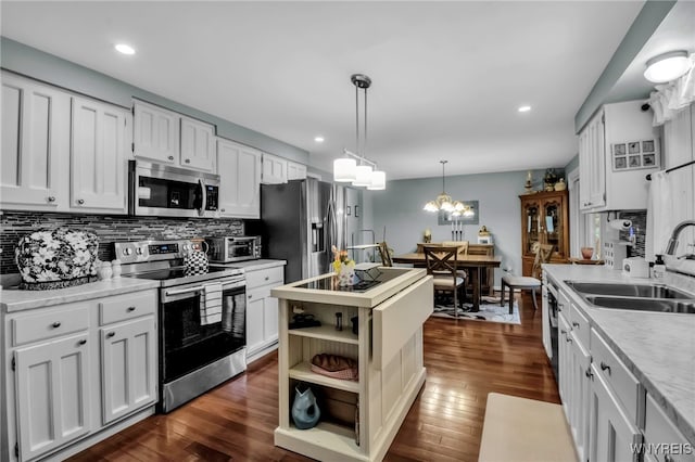 kitchen with light countertops, appliances with stainless steel finishes, decorative backsplash, and a sink