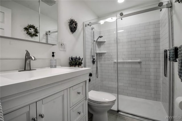 bathroom with vanity, toilet, and a stall shower