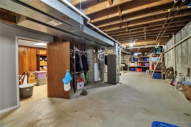 unfinished basement with visible vents and heating unit