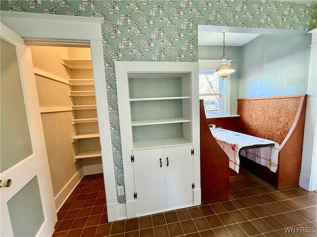 interior space with built in features, wallpapered walls, and baseboards