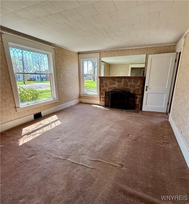 unfurnished living room with carpet flooring and a stone fireplace