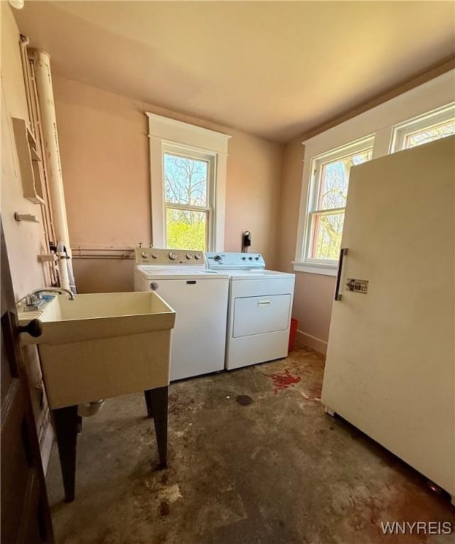 clothes washing area with a sink, laundry area, and independent washer and dryer