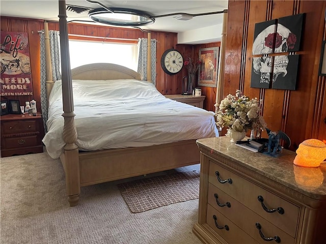 carpeted bedroom featuring wood walls