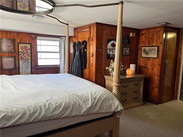 bedroom with wood walls and carpet floors