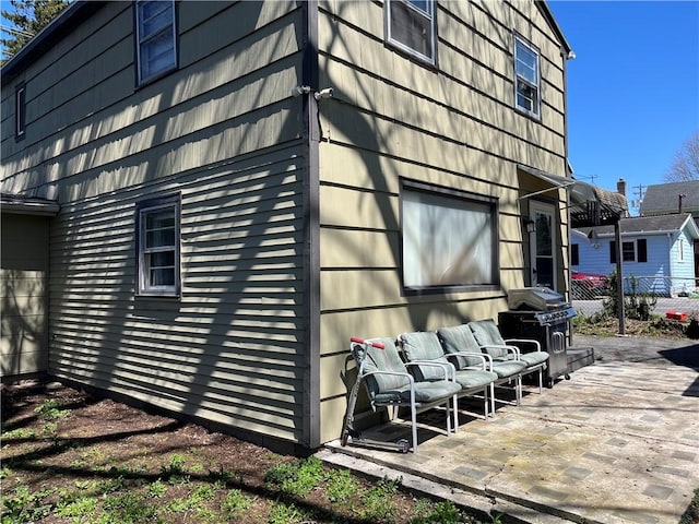 view of side of home with a patio and fence