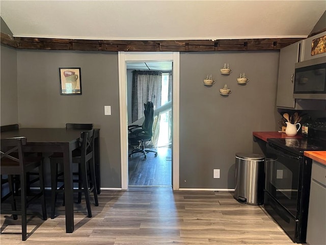dining space with light wood-style flooring and baseboards