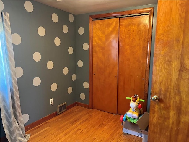 details featuring visible vents, wood finished floors, and baseboards