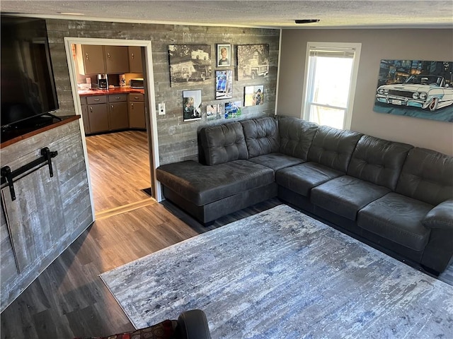 living room with a textured ceiling, wood finished floors, and visible vents