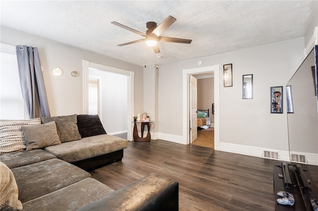 living area featuring a textured ceiling, wood finished floors, a ceiling fan, and visible vents