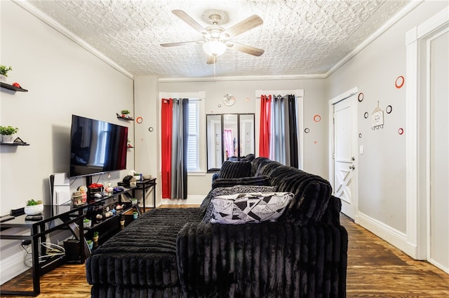 living area with a ceiling fan, wood finished floors, and baseboards