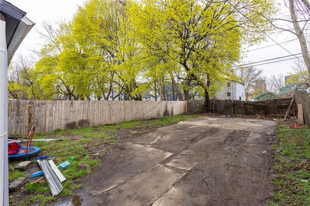 view of yard with a patio, a trampoline, and a fenced backyard