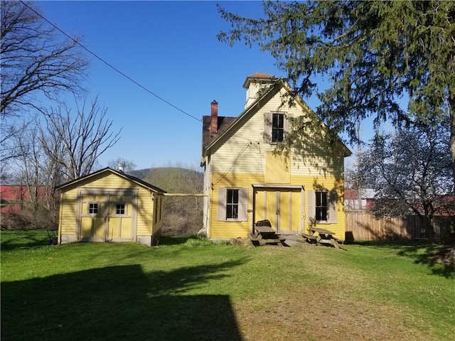 20 S Main St, Sherburne, NY 13460 - back of property featuring a chimney, fence, an outdoor structure, and a lawn