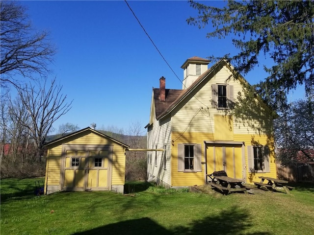 20 S Main St, Sherburne, NY 13460 - back of house with a lawn, a chimney, and an outbuilding