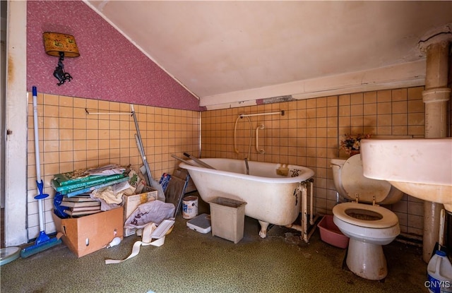 39 Ward St, Little Falls-City, NY 13365 - bathroom with toilet, wallpapered walls, tile walls, vaulted ceiling, and a soaking tub