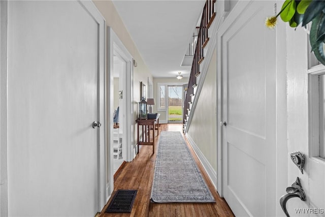hall featuring wood finished floors and visible vents