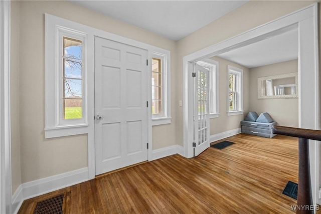 entryway featuring baseboards, visible vents, and wood finished floors