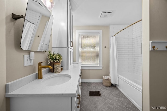 bathroom featuring shower / tub combo, visible vents, vanity, and baseboards
