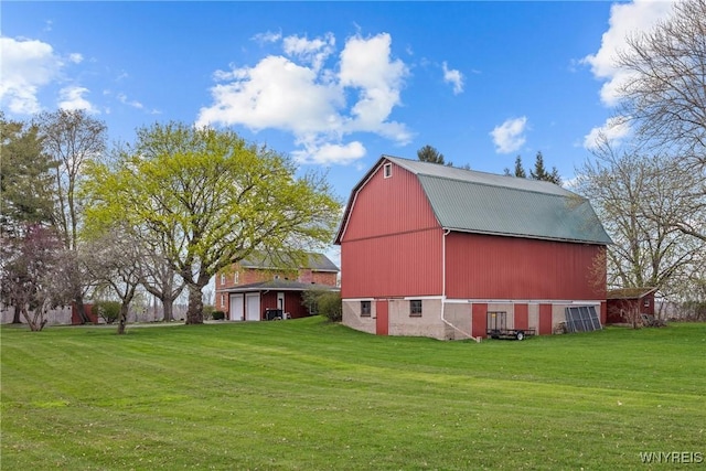 view of barn featuring a yard and a garage