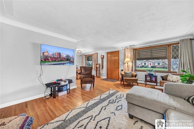 living area featuring baseboards, baseboard heating, and wood finished floors