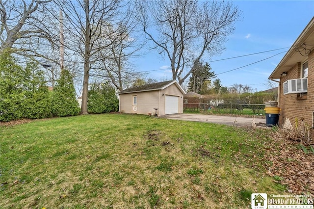 view of yard with driveway, an outbuilding, a detached garage, fence, and cooling unit