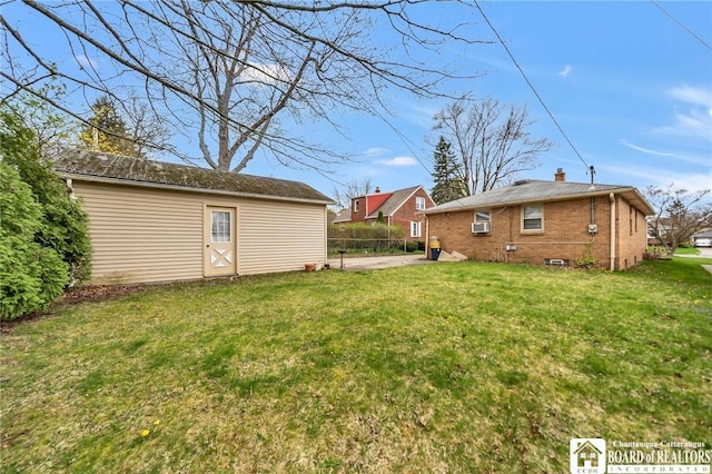view of yard with a patio area, fence, and an outbuilding