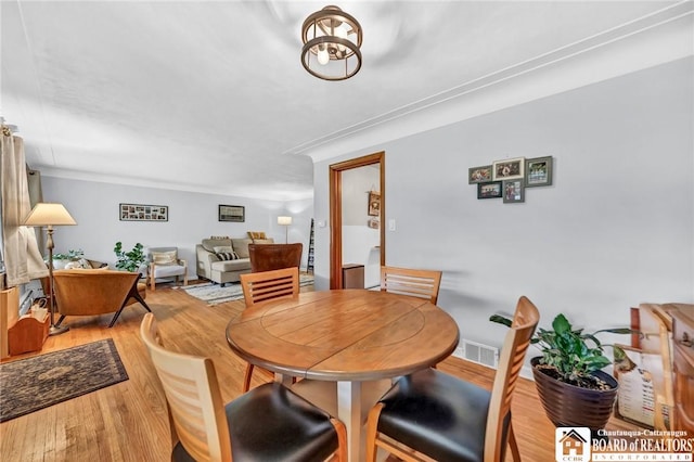 dining space featuring visible vents and light wood-type flooring
