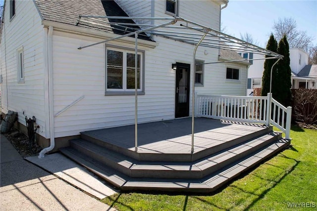 back of house with a shingled roof and a wooden deck