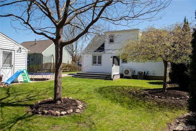 view of yard with central AC and a trampoline
