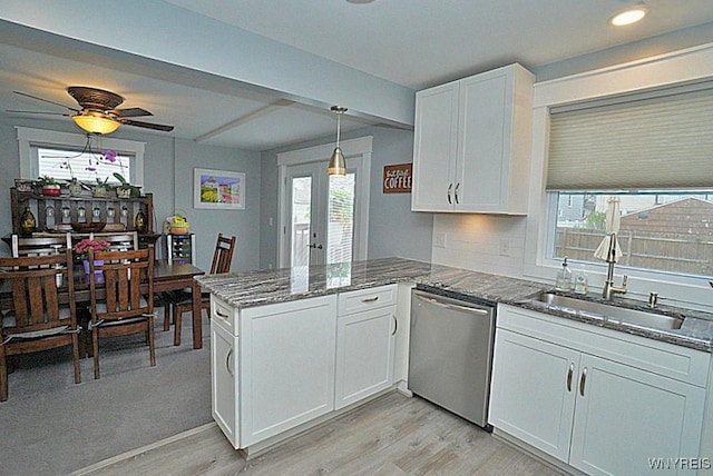 kitchen with stainless steel dishwasher, a sink, white cabinets, light wood finished floors, and a peninsula