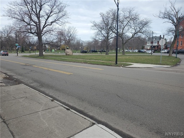 view of street featuring traffic signs, sidewalks, and curbs