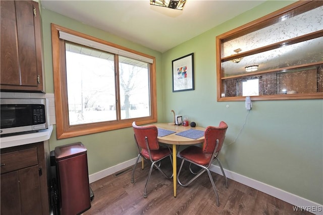 dining area with visible vents, wood finished floors, and baseboards