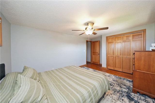 bedroom with wood finished floors, a ceiling fan, and a closet