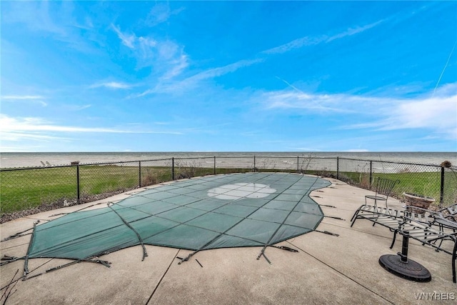 view of swimming pool featuring a fenced in pool, a water view, and fence