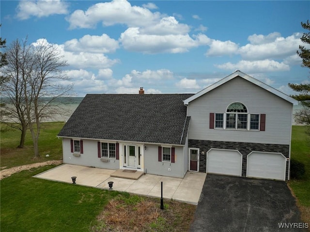 view of front of property with a front yard, a chimney, stone siding, and aphalt driveway