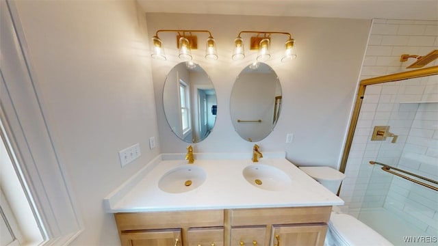 bathroom featuring tiled shower, toilet, and vanity