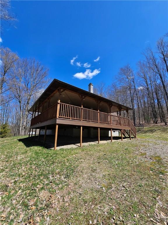 back of house featuring a wooden deck and a chimney