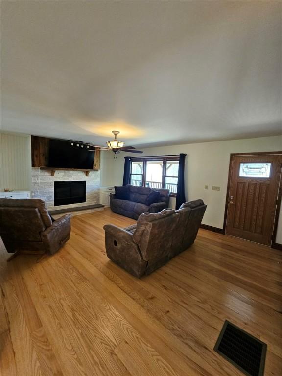 living room with visible vents, a healthy amount of sunlight, wood finished floors, and a fireplace