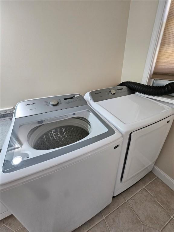 laundry room with light tile patterned floors and separate washer and dryer