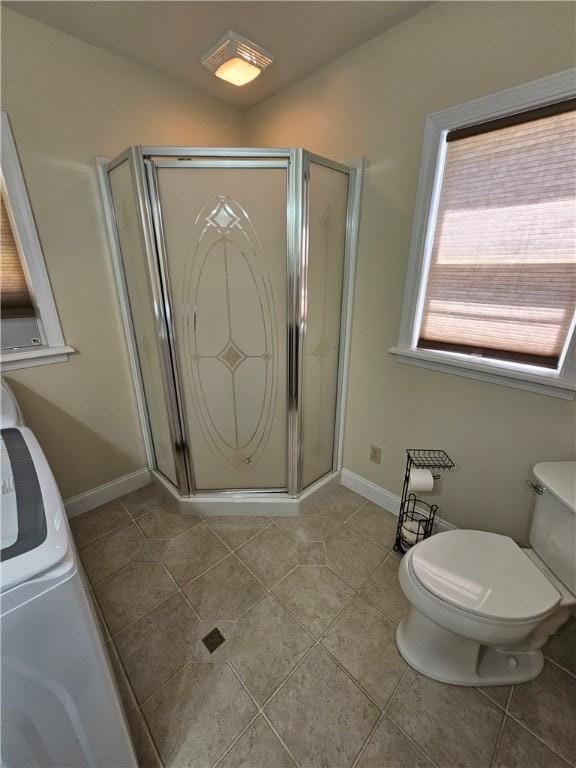 full bathroom featuring toilet, a shower stall, and tile patterned floors