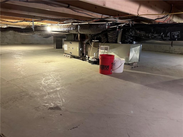 unfinished basement featuring heating unit