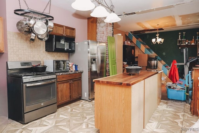 kitchen with decorative backsplash, appliances with stainless steel finishes, a chandelier, butcher block counters, and a toaster
