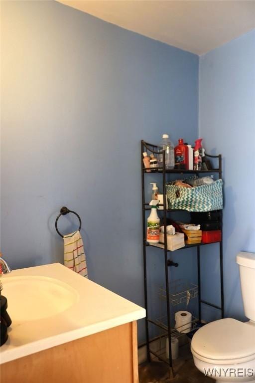 half bath featuring vanity and toilet