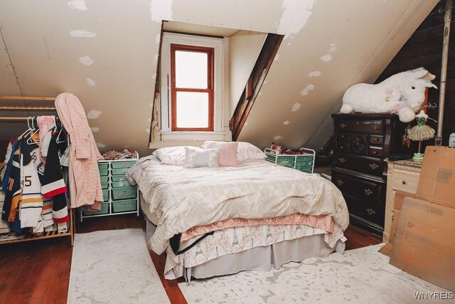 bedroom featuring lofted ceiling and wood finished floors
