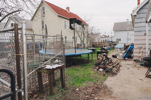 view of yard featuring a trampoline and fence
