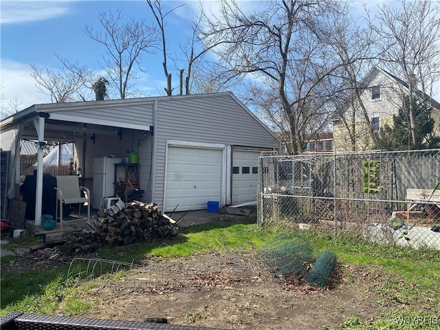 garage with freestanding refrigerator and fence