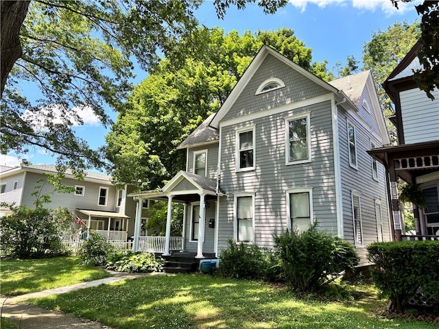 greek revival inspired property featuring covered porch and a front lawn
