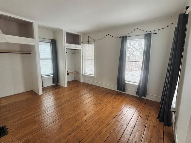 unfurnished bedroom with hardwood / wood-style floors and baseboards