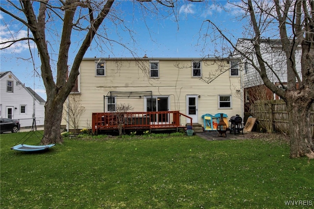 back of house featuring a lawn, a fenced backyard, and a wooden deck