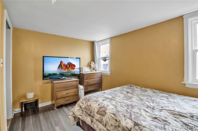 bedroom with baseboards and wood finished floors